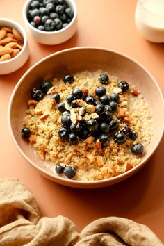 a bowl of oatmeal with blueberries and almonds on the side