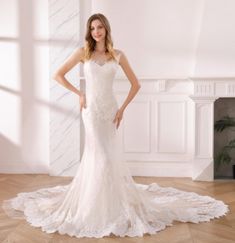 a woman in a white wedding dress posing for the camera with her hands on her hips