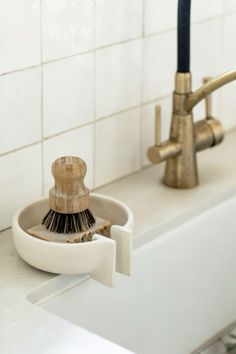 a bathroom sink with a brush and soap dispenser