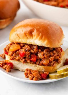 a sloppy joe sandwich sitting on top of a white plate