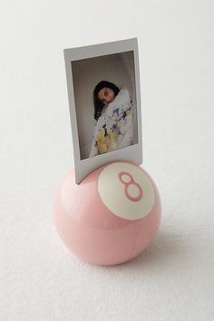 a pink and white ball with a photo on it sitting next to a card holder