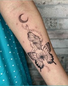 a woman's arm with a butterfly and crescent tattoo on the left side of her arm