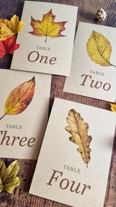 four cards with autumn leaves on them and the words table, two, three, four