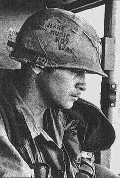 a black and white photo of a man wearing a fireman's helmet with writing on it