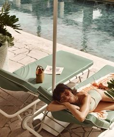 a woman laying in a lawn chair next to a pool