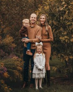 a family posing for a photo in front of some trees