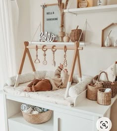 a baby laying on top of a white crib next to a shelf filled with items