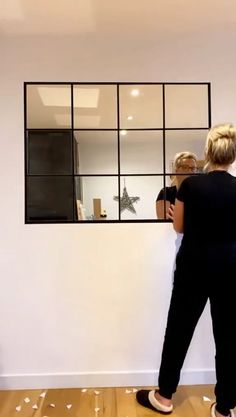 two women are standing in front of a mirror and confetti is falling on the floor