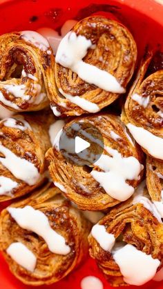 a red bowl filled with pastries covered in icing