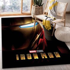 the iron man movie poster is displayed in front of a room with a chair and potted plant