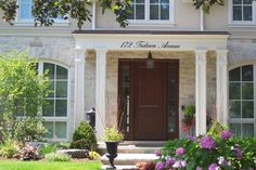 the front entrance of a home with flowers and trees