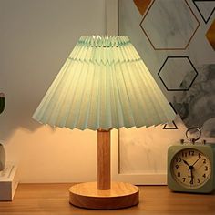 a lamp that is sitting on top of a table next to a clock and other items