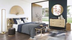 a bed room with a neatly made bed and a large mirror on the wall above it