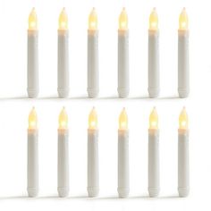 eight white candles with yellow lights on them