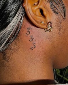 the back of a man's head with tattoos on his neck and behind ear