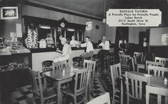 black and white photo of people sitting at tables in a restaurant with menus hanging on the wall