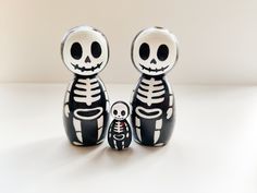 two black and white skeleton figurines sitting next to each other