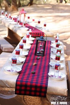 a long table is set up with plates and cups on it for an outdoor dinner