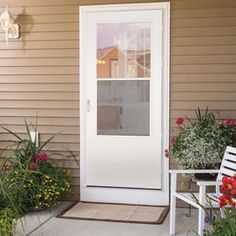 the front door is open and there are flowers in pots on the steps to the porch