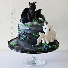 a birthday cake with an image of a dragon and a baby dragon sitting on it