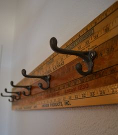 there is a ruler on the wall with hooks hanging from it's sides and two measurings on each side