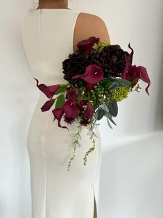 a woman in a white dress holding a bouquet of flowers