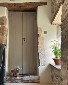 an entry way with stone walls and potted plants