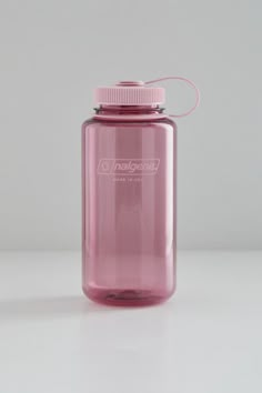 a pink water bottle sitting on top of a white table