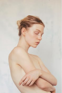 a nude woman with her arms crossed