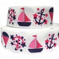 two white ribbons with red and blue sailboats on them, one has an anchor