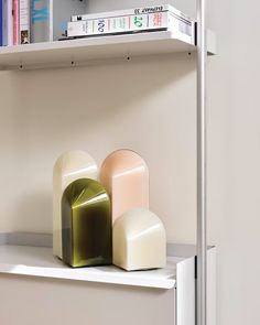 two vases sitting on top of a white shelf