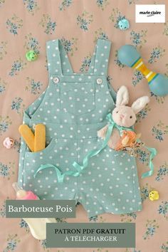 a baby's blue polka dot romper with bunny on it and other toys