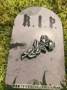 a grave marker with a leaf and acorn on it sitting in the green grass