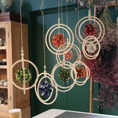 a bunch of ornaments hanging from the ceiling in front of a green wall with flowers on it