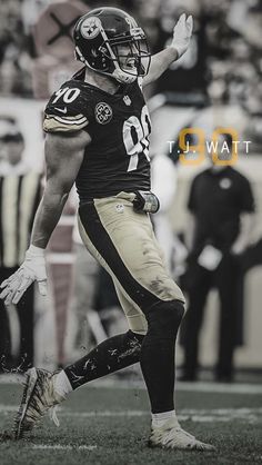 a black and white photo of a football player on the field with his arm in the air