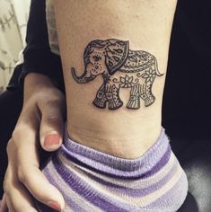 an elephant tattoo is on the ankle of a woman's right arm and leg