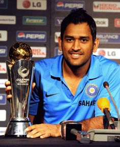 a man in blue shirt holding up a trophy