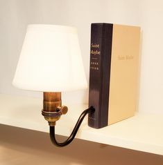 a lamp on a shelf next to a book