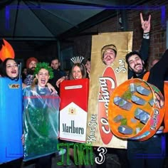 group of people dressed up in costumes and holding signs with sushi on them at a party