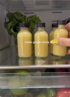 a person reaching for some juice in front of an open refrigerator