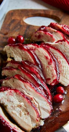 sliced up meat with cranberry sauce on a cutting board