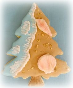 a cookie shaped like a christmas tree with seashells on it