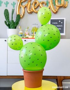 a green cactus plant sitting on top of a yellow table