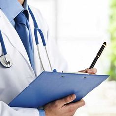 a doctor writing on a clipboard with a pen in his hand while holding a clipboard