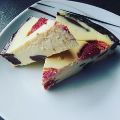 two pieces of cheesecake with strawberries on top