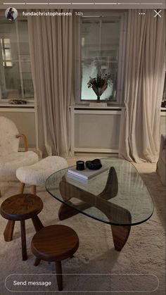 a living room filled with furniture and a glass top table in front of a window