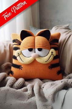 a crocheted cat pillow sitting on top of a bed