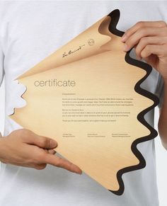 a person holding up a certificate in their left hand, with the word certificate printed on it