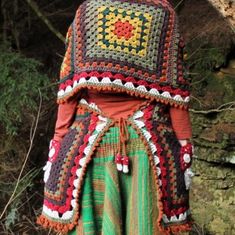 a woman wearing a crocheted shawl and skirt