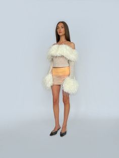 Made to order. Ships in 1 to 3 weeks This fitted top hangs off the shoulders and features a faux fur-trimmed neckline, finishing with matching cuffs. The fabric composition of 90% mohair and 10% wool ensures a soft and comfortable feel with a touch of stretch. The off white colour makes it versatile in styling—perfect for both casual and elevated looks. Care Instructions Hand wash in cold water / no machine wash / handle with care. Do not bleach / Non-chlorine bleach allowed. Lay flat to dry / d Heart Cutout Dress, Neckline Finishing, Floral Denim Pants, Vegas Aesthetic, Lirika Matoshi, Off White Colour, Tulle Mini Dress, Fur Top, Chain Dress